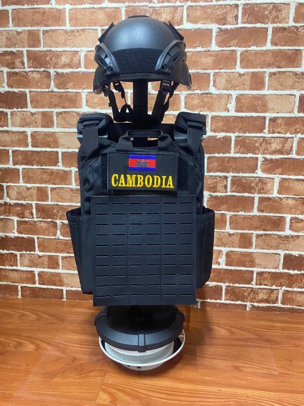 Black tactical vest with Cambodia patch and helmet on display.