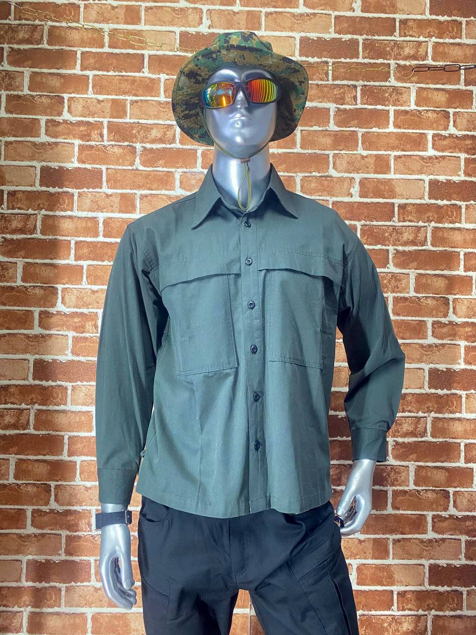 Green tactical shirt with long sleeves and front pockets, outdoor use.