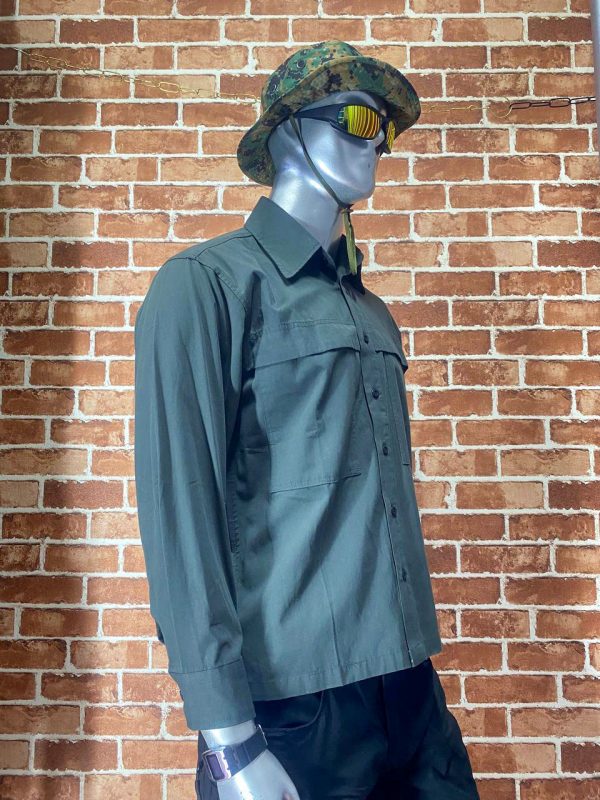 Tactical long-sleeve shirt in green on mannequin with camouflage hat and sunglasses.