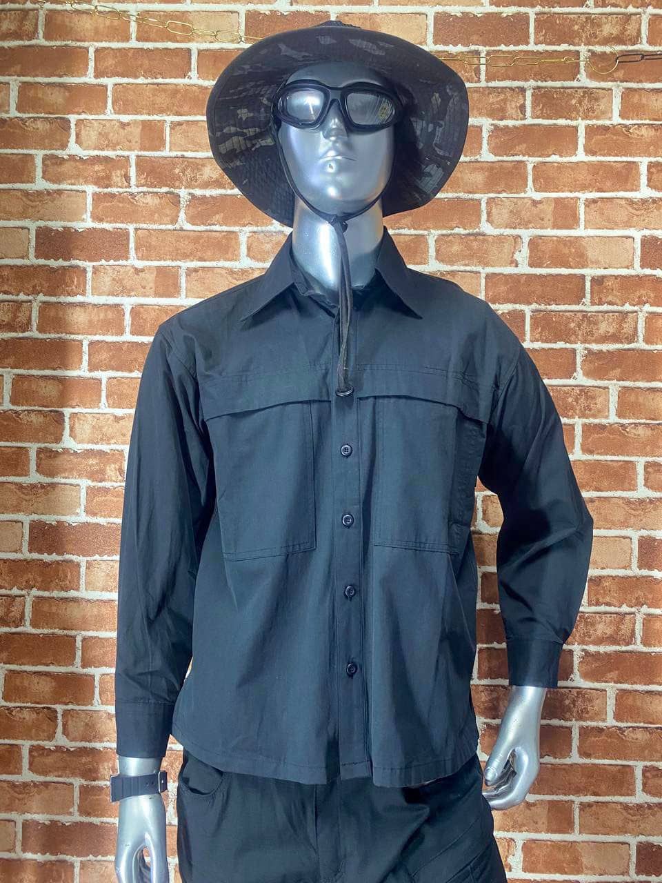 Black tactical shirt with long sleeves and hat, outdoor gear for tactical use.