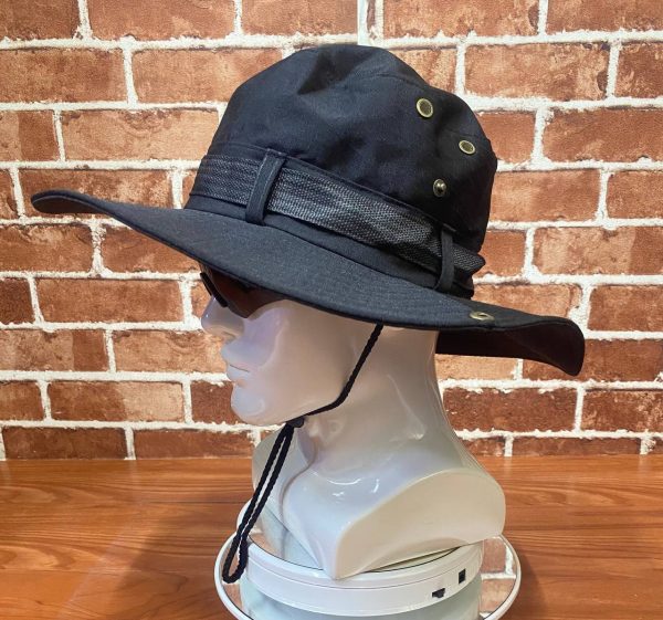 Black tactical hat with chin strap and metal eyelets for outdoor use.