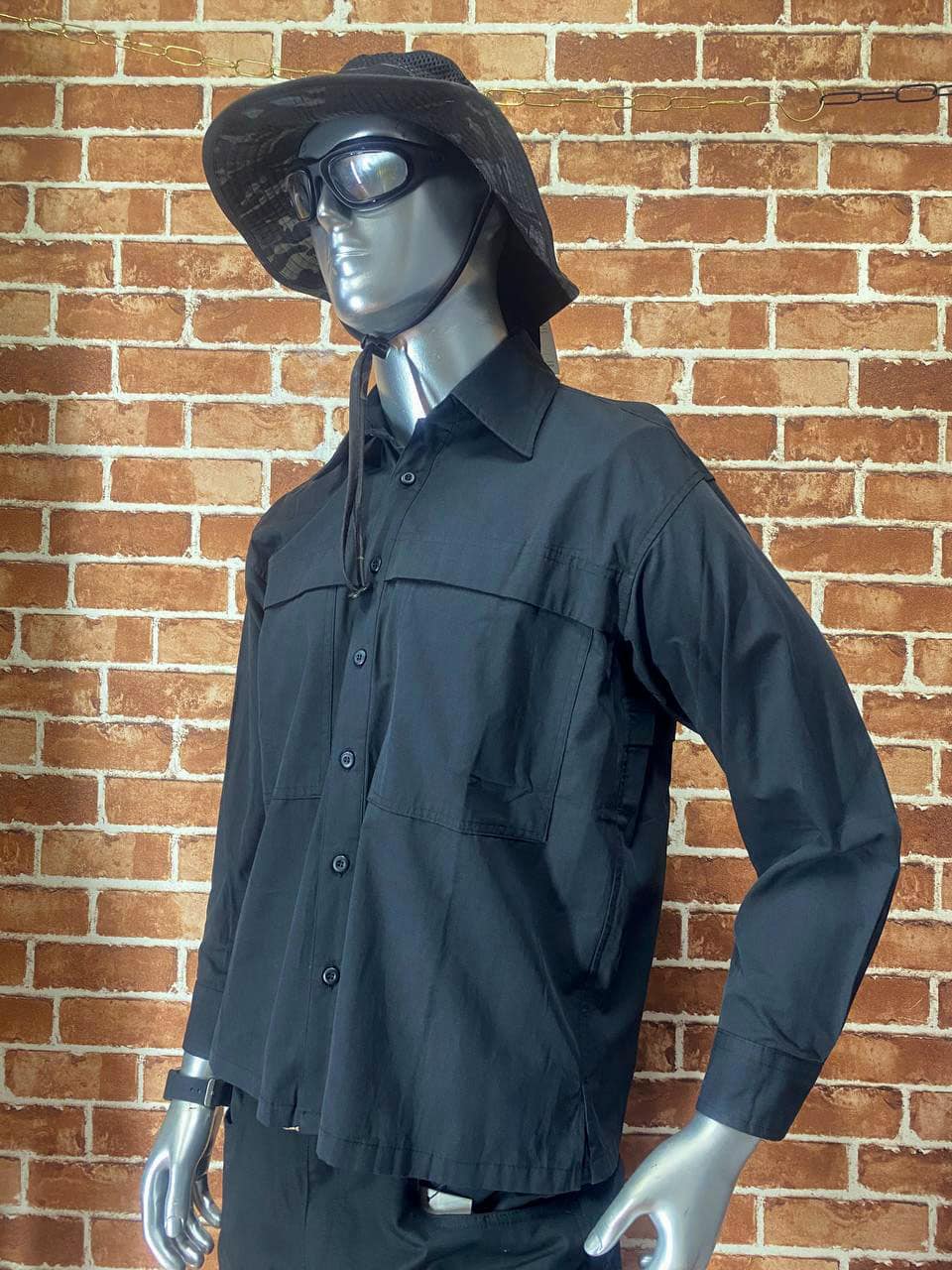 Black tactical shirt with long sleeves and button front, displayed on mannequin.
